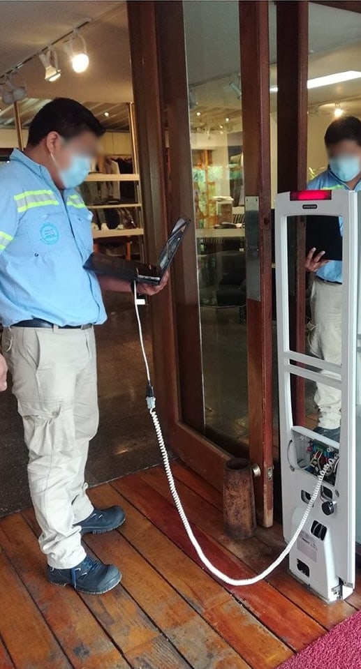 Técnico da Sensorseg testando a detecção de um par de antenas na entrada de uma loja